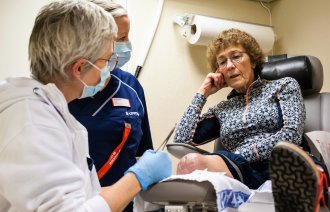Sårsykepleiere på Unicare Bakke steller operasjonssåret til amputasjonspasient Kari Wetlesen.