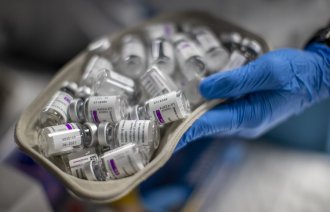 Bildet viser en hånd som holder et pussbekken med hetteglass.