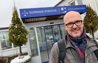 En mann foran en sykehusbygning