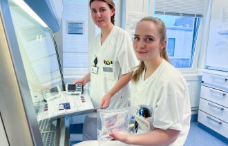 Bildet viser to kvinnelige sykepleiere som holder i medisinsk utstyr