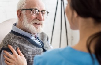 Bildet viser en hjemmesykepleier på besøk hos en pasient