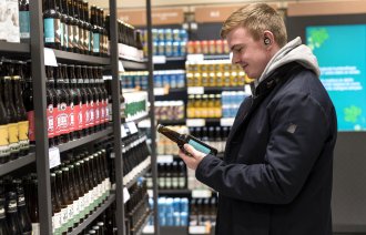 mann handler på systembolaget