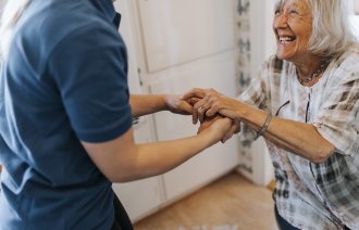 Bildet viser en sykepleier som geleider en pasient