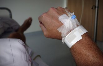 Bildet viser hånden til en mann som har perifert venekateter.