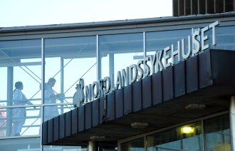 Bildet viser helsepersonell gjennom et vindu på Nordlandssykehuset