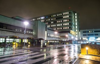 Bildet viser Stavanger universitetssjukehus (SUS) fra veistubben inn mot hovedinngangen i mørket.