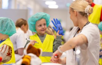 Bilde viser sykepleiestudent sammen med barnehage gutt.