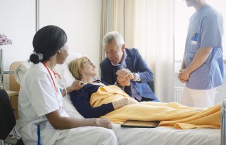 Bildet viser en pasient sammen med pårørende og helsepersonell.