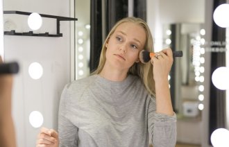 Bildet viser en ung kvinne som sminker seg.