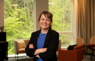 Bildet viser innleggsforfatter Aina Kolle. Hun smiler til kamera og holder armene i kors.