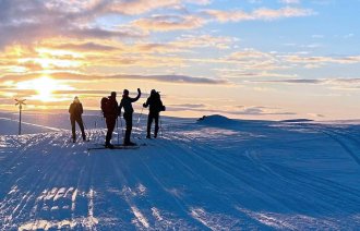 Bildet viser Lill Sverresdatter på ski i solnedgang med sykepleiervenner.