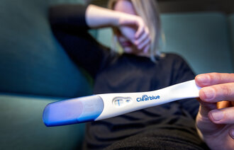 Bilde av kvinne som har tatt graviditetstest