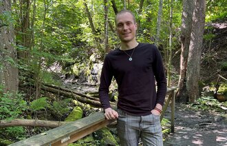 Bildet viser Daniel Tørresvoll Stabu på en bro i skogen