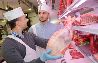 Bildet viser to menn som holder opp et lammelår