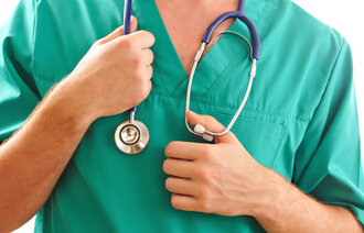 Bildet viser overkroppen til en lege med stetoskop og operasjonsuniform