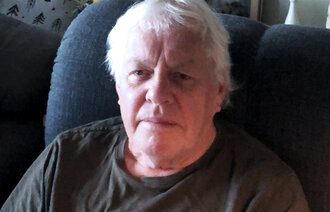 Bildet viser Kai Henning Andersen som sitter i en blå lenestol og ser mot kamera