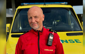 Bildet viser innleggsforfatteren i uniform foran en ambulanse