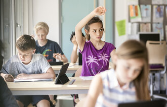 Bildet viser unge skolebarn i et klasserom