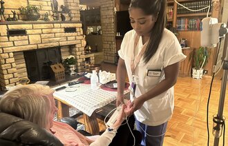 Bildet viser Pathmasri som er på hjemmebesøk til en pasient