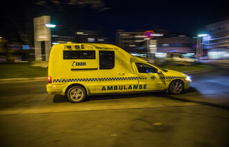 Bildet viser en ambulanse som kjører om kvelden