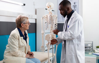 Bilde av lege og pasient med skjelett