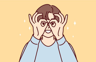 Bildet viser en gutt som lager briller med hendene.