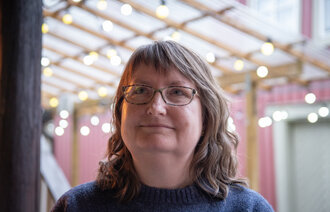 Anne Cathrine Hovind ser litt opp fra kamerat på et kafe i Trondheim