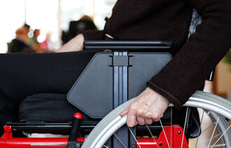 Bildet viser et utsnitt av en person som sitter i rullestol