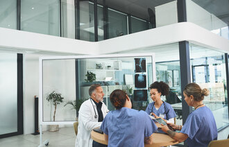 Bildet viser helsearbeidere som sitter og snakker sammen.