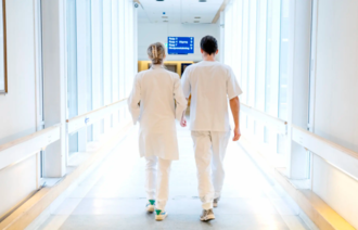 Bildet viser helsepersonell som går i en gang.