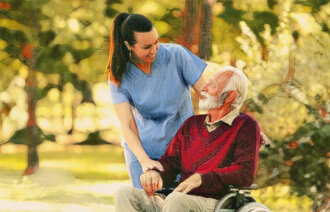 Bildet viser en eldre pasient i rullestol og en sykepleier som er i naturen