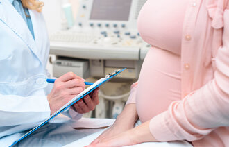 Bildet viser et utsnitt av en gravid kvinne hos legen