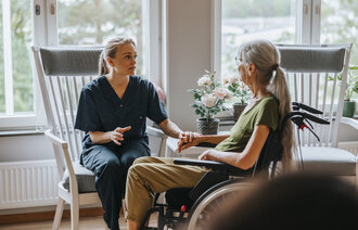 Bildet viser en sykepleier som er hjemme hos en palliativ pasient