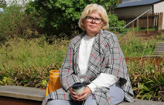 Bildet viser kreftoverleveren Ingunn Haugenes på en benk