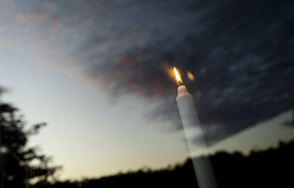 Bildet viser gjenskinnet av et tent lys i et vindu