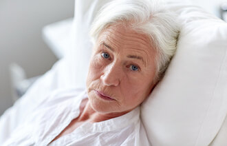 Bildet viser en trist eldre pasient med kreft