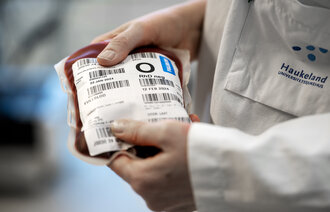 Bildet viser hender som holder en blodpose.