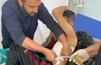 Bildet viser en sykepleier i Gaza som steller en pasient