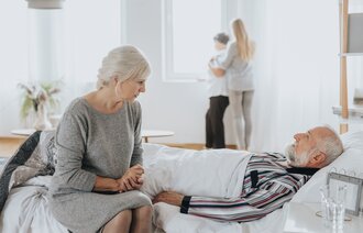 Bildet viser en mann som dør hjemme med familien rundt seg