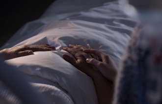 Holder døende pasient i hånden Holder døende pasient i hånden