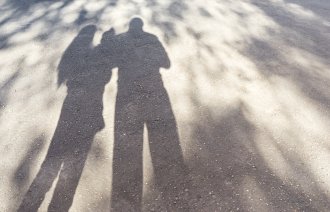 Bildet viser skyggen av et par med et barn på armen