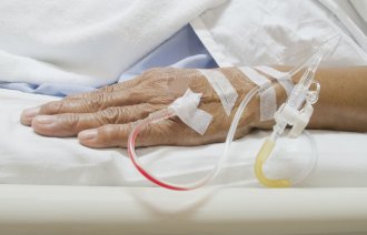 Sykehus, bemanning Bildet viser en hånd med venekanyle i.