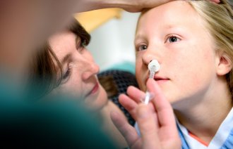 Jente får deksmedetomidin før operasjon Bildet viser ei jente som får deksmedetomidin i form av nesespray før operasjon