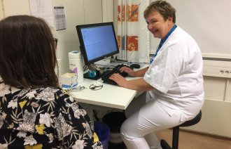 Bildet viser en øyesykepleier som veileder en pasient