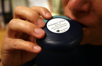 Viser en mann som inhalerer astmamedisin