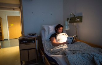 Astrid ligger i senga og leser bok Astrid ligger i senga og leser bok