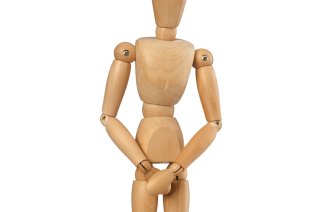 Bildet viser en bevegelig tredukke som står og holder hendene foran skrittet.