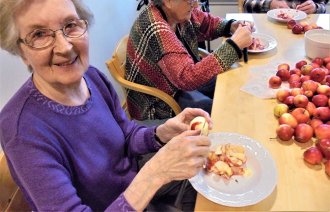 bildet viser beboere ved Åfjord helsesenter som skreller epler