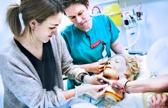 Bildet viser sykepleiere som øver på trakeostomi på en simuleringsdukke.