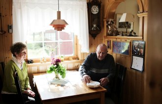 Berit og Bardo Rolseth med medisindispenseren Pilly hjemme på kjøkkenet i Selbu